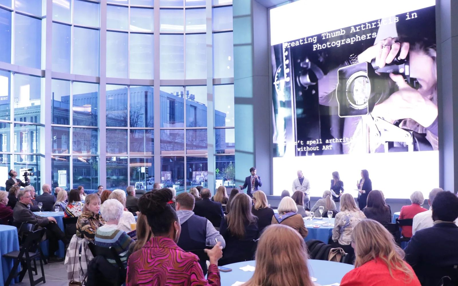 Michael Hollins speaking at the UNMC Healing Arts event with artist Laurie Victor Kay in the Davis Global Center