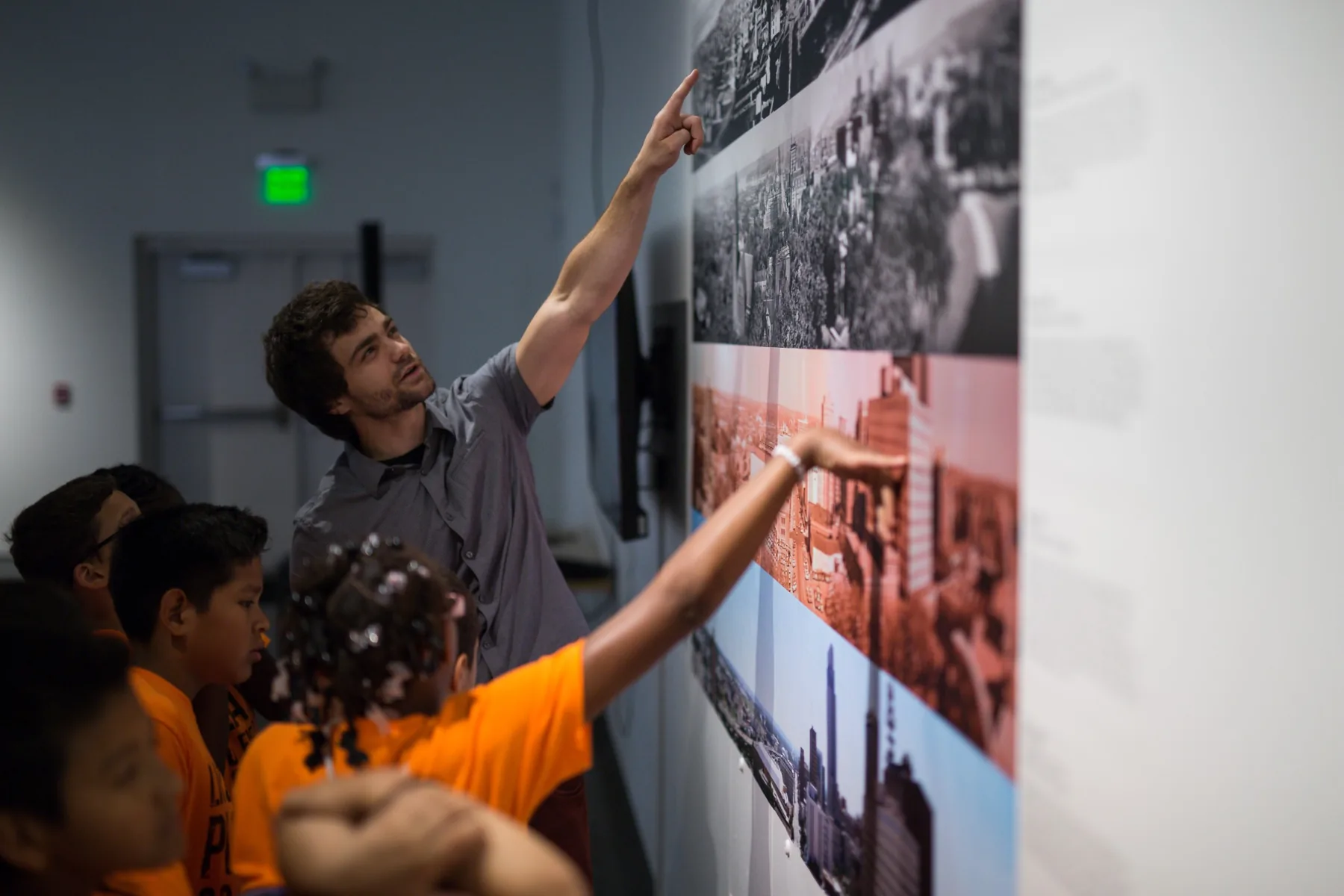Michael Hollins and students pointing to exhibition material during Storytelling at KANEKO in 2016